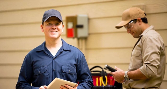 HVAC technician in front of a house